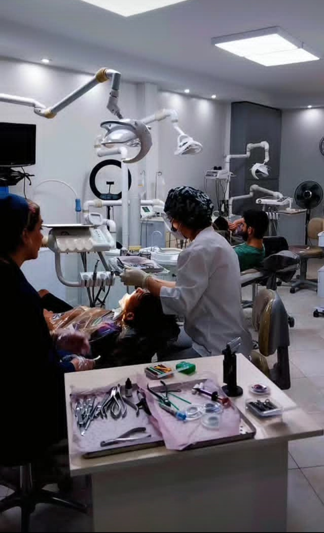 متخصص ارتودنسی و تیم در حال درمان بیمار در کلینیک دندانپزشکی