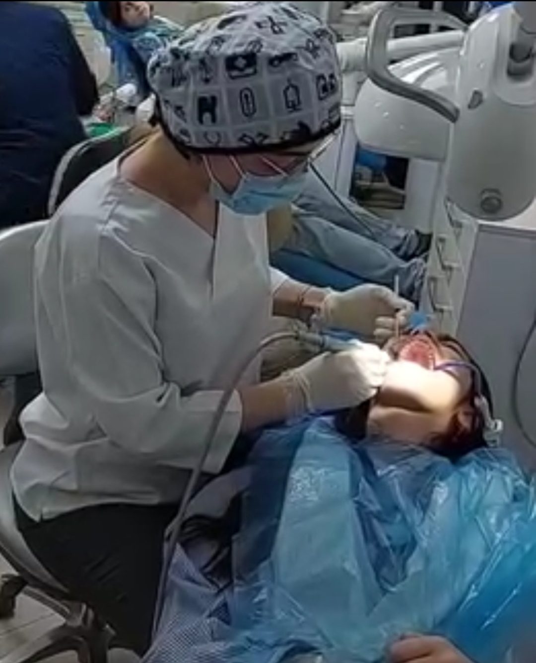متخصص ارتودنسی در حال انجام درمان و تنظیم براکت روی دندان بیمار